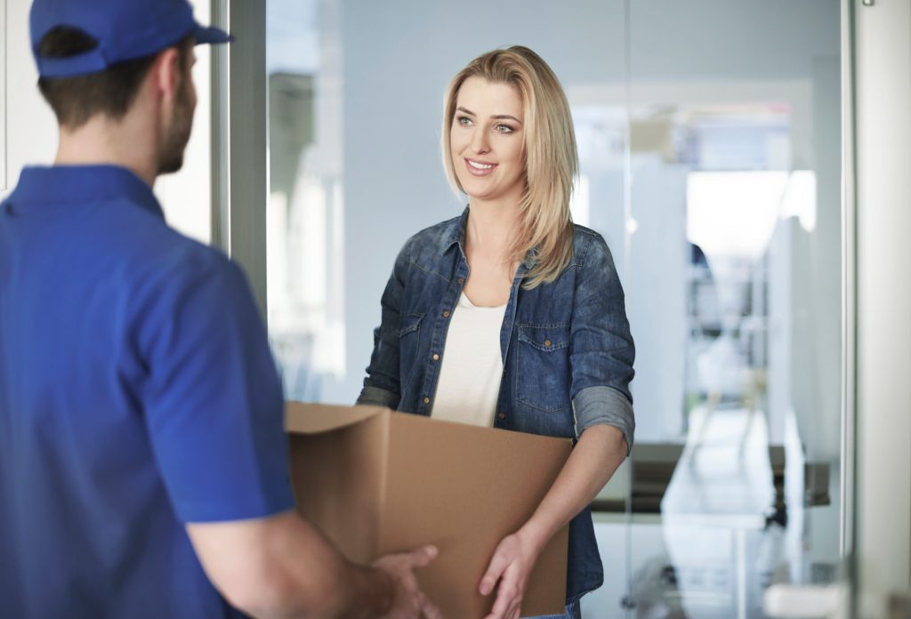 Woman getting a parcel from delivery man
