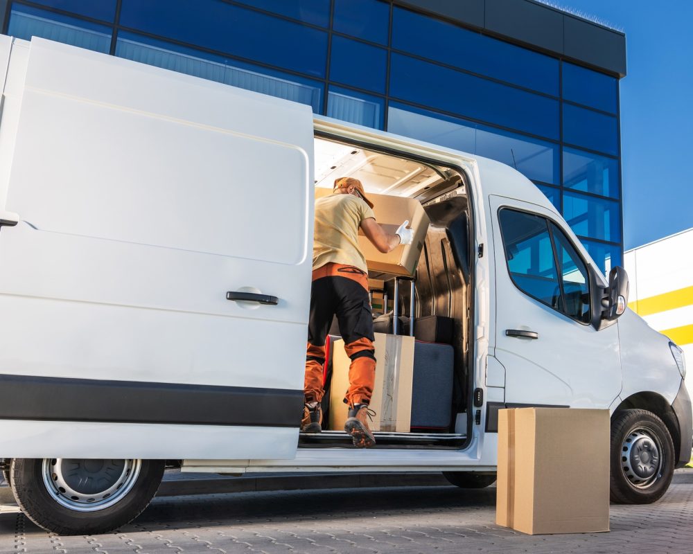 Delivery Worker Loading Boxes Into Van